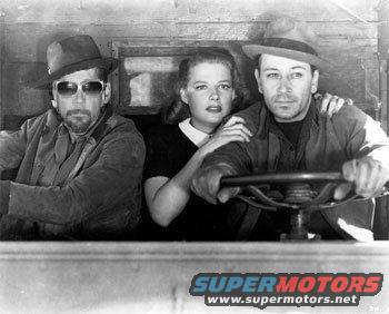 Three people, two men and a woman, inside a vehicle. The man on the right is driving