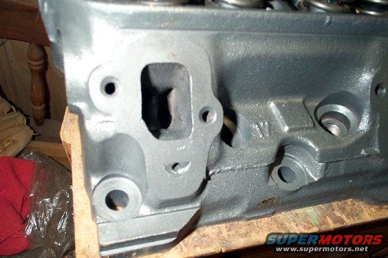 Gray engine cylinder head with visible ports and bolt holes