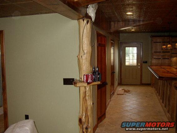 room with wood pillar, cans of soda, and a door