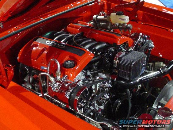 Red engine bay with a GTO-labeled engine cover, chrome accents, and an air filter
