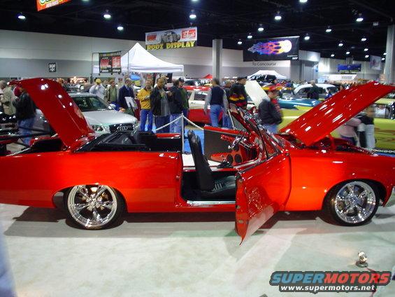 Red convertible with doors and hood open, custom wheels