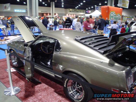 1969 Ford Mustang coupe, tan paint, black hood stripes, louvers on rear window, open doors and hood