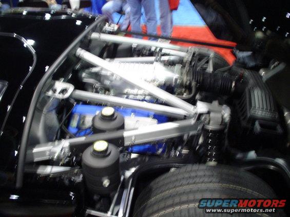 Engine bay showing supercharger, intake, and suspension components. Supermotors.net logo visible