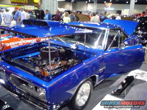Blue 1969 Plymouth Barracuda with hood open, showing engine and scoop