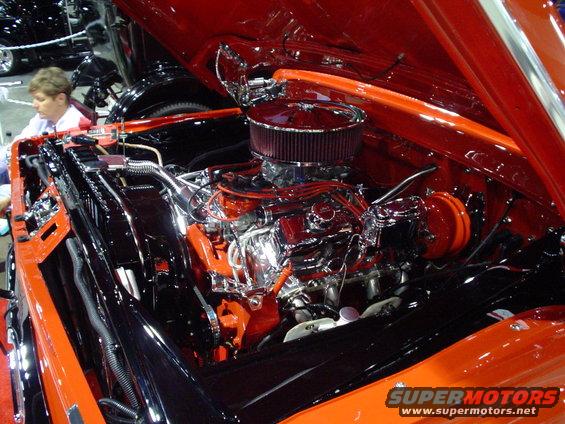 engine bay with chrome V8 engine, air filter, and orange accents