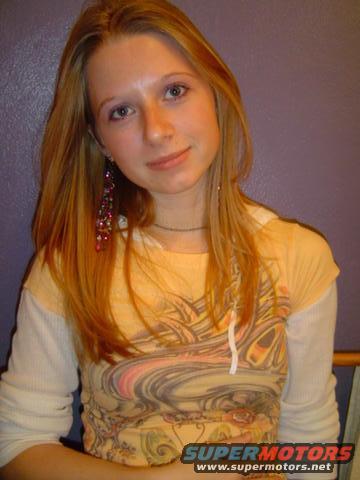 Woman with long blonde hair wearing a layered shirt with a graphic print