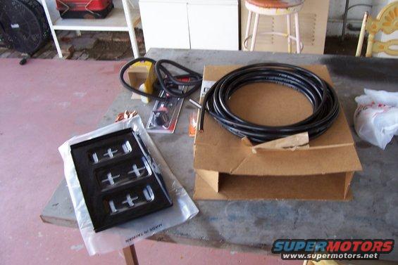 Battery relocation parts including a black tray and coiled hose