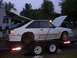 1988 Ford Mustang - White 1988 Ford Mustang on a trailer, hood and trunk open, missing rear wheels.