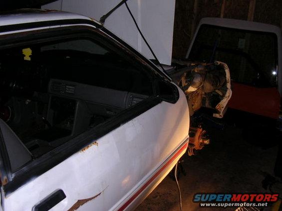 1988 Ford Mustang interior and engine bay, with another vehicle visible in the background