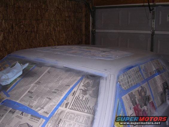 Car roof covered in primer and taped off for painting