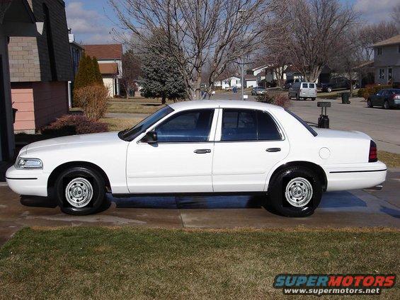 White sedan parked in a driveway. It has black rims and tinted windows