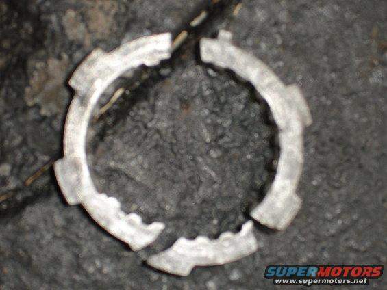 Broken metal ring with internal notches, appears to be a vehicle part
