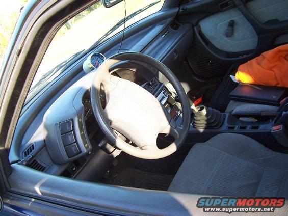 Car interior with aftermarket gauge and manual shifter