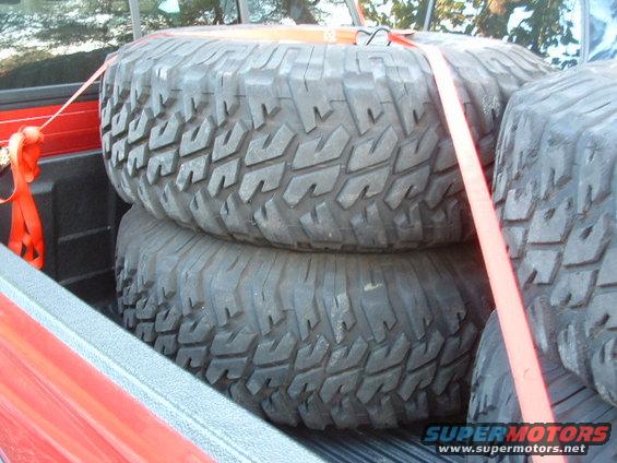 Spare tires strapped in red truck bed
