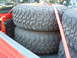 1994 Jeep YJ - Spare tires are secured with orange straps in the bed of a red pickup truck.
