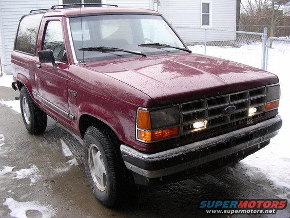 Maroon 1989 Ford Bronco II parked on wet ground with snow