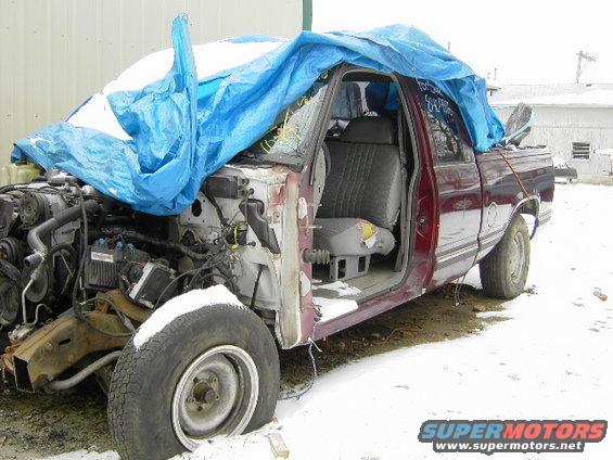 Maroon 1997 Chevrolet C/K Pickup, 3/4 front view, covered with a blue tarp