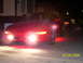 1994 Ford Probe - A red coupe is parked at night with its fog lights illuminated. Another vehicle is parked behind it.