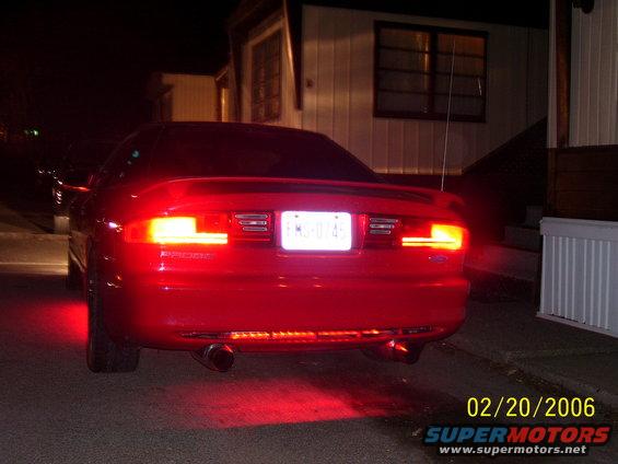 Red 1994 Ford Probe rear view at night, license plate FMS-0145 illuminated