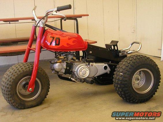 Red three-wheeled ATV with flames and the number 70 on the gas tank. Honda logo visible on the engine