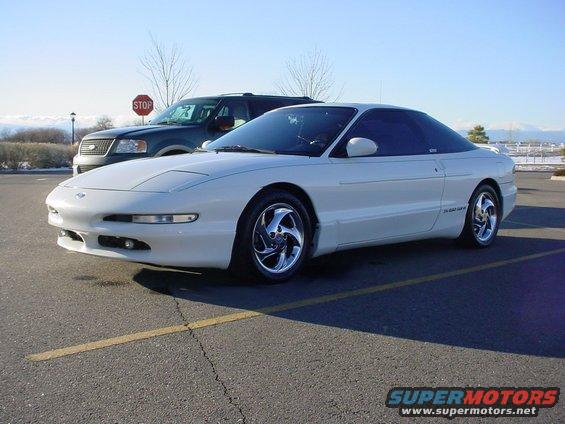 White 1996 Ford Probe coupe parked in a lot, 3/4 front view. A dark SUV is behind it