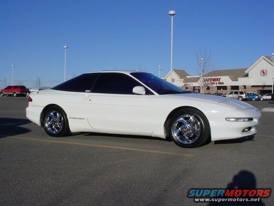 White coupe with tinted windows and chrome wheels parked in a lot