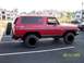 1979 Ford Bronco - This red 1979 Ford Bronco is shown from the front-three-quarter view, a spare tire mounted on the rear.