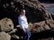 1989 Ford Bronco - A woman stands on a rocky shoreline with the ocean in the background.