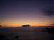 1989 Ford Bronco - The sun sets over the ocean, casting a gradient of purple and orange hues across the sky.