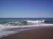 1989 Ford Bronco - Waves roll onto the shore on a sunny day at the beach.