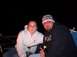 1989 Ford Bronco - Two people are sitting in chairs next to a campfire in the dark. The man wears a beanie and the woman wears a hoodie.