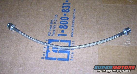 Braided metal hose with silver fittings on cardboard