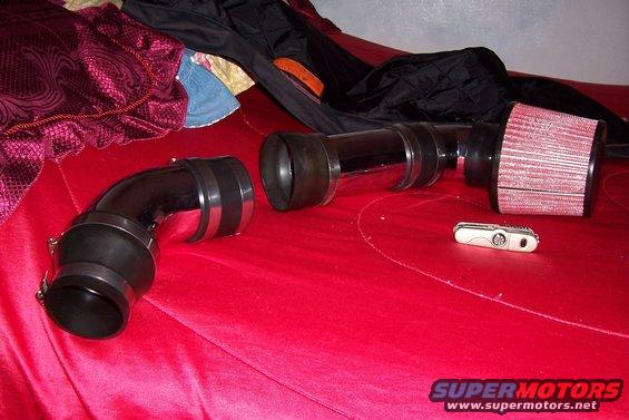 Cold air intake tubing and filter on a red surface