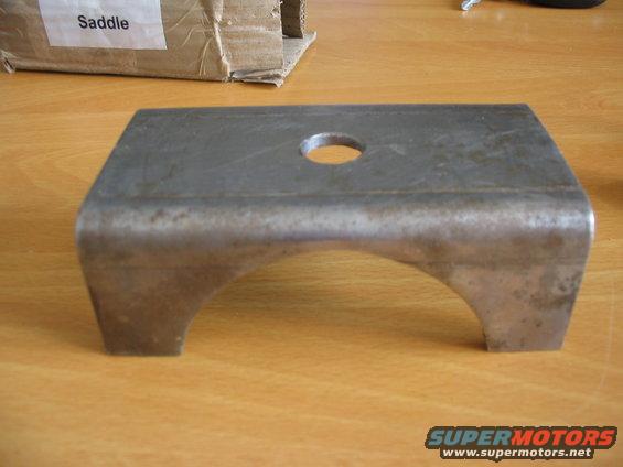 Metal U-shaped part with a hole in the top, labeled 'Saddle' on a box behind it