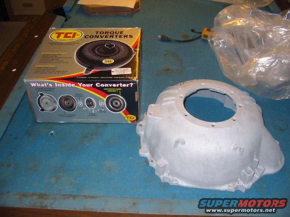 TCI torque converter box and aluminum bell housing on a blue surface