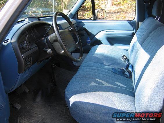 Blue fabric bench seat and dashboard of a truck, viewed from the passenger side