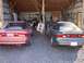 1996 Ford Probe - Two Ford Probes, a pink one and a gray one, are parked side-by-side in a rustic wooden shed.