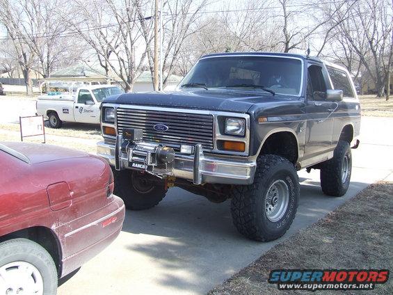 Dark blue Ford Bronco with a winch on the front bumper, lifted suspension, and off-road tires