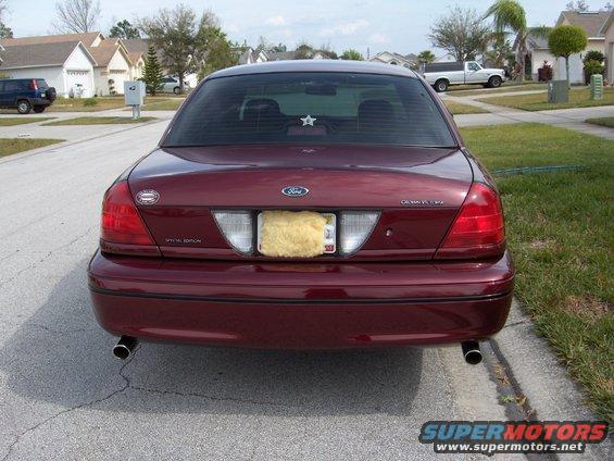 Rear view of a maroon 2004 Ford Crown Victoria with tinted windows and a star decal