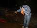 1979 Ford Bronco - A person is cleaning an engine block with a pressure washer in a dark, outdoor setting.