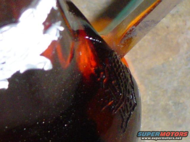 Dark red taillight lens with textured black trim and white debris