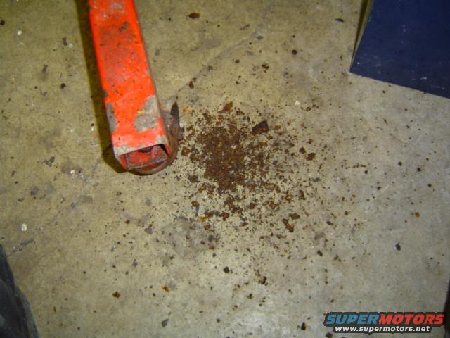 orange jack leg and pile of rust flakes on concrete floor