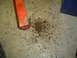 1979 Ford Bronco - A close-up view shows rust debris scattered on a concrete floor next to an orange jack.