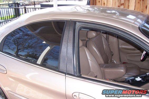 Tan interior and carbon fiber door pillars of a sedan
