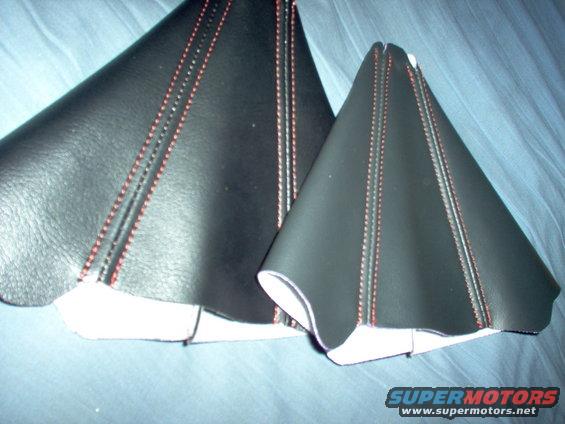 Two black leather shift boot covers with red stitching. One is larger than the other