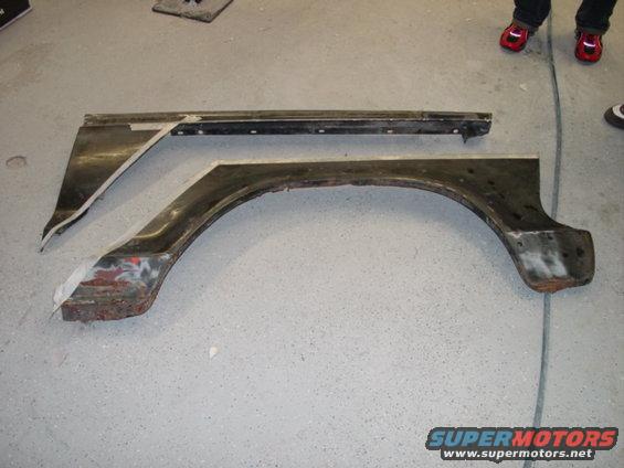 Two removed fender sections, one with an arch, laid on a concrete floor