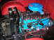 1963 Ford E100 - The engine bay of a 1963 Ford E100 features a bright blue engine block with chrome valve covers and a blue air cleaner assembly.