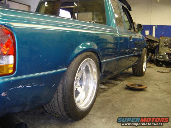 Rear quarter view of a teal 1997 Ford Ranger with aftermarket wheels and lowered suspension