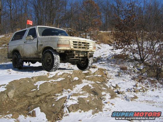 White 1995 Ford Bronco navigating a snowy, rocky trail