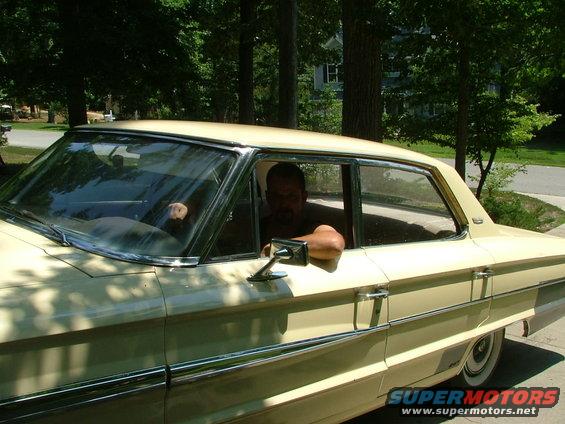 Man leans on the door of a light-colored 1963 Ford Galaxie